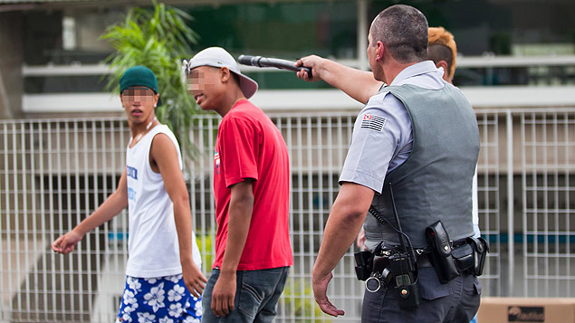 O fotógrafo Bruno Poletti, da Folhapress, fotografou o momento em que um PM ameaçava com o cassetete um garoto que integrava o 'rolezinho'