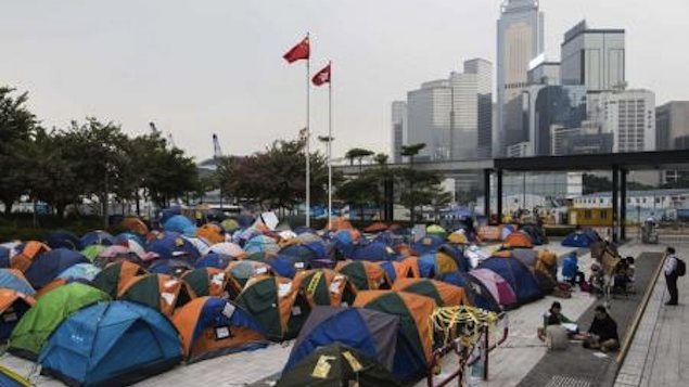 Bandeiras da China e de Hong Kong vistas acima de barracas de manifestantes acampados em área ocupada de Hong Kong