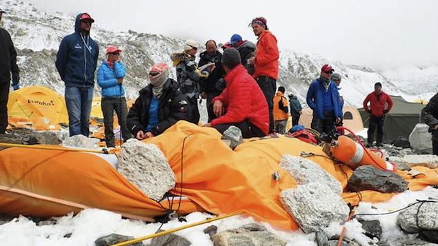 Montanhistas observam os restos do acampamento destruída pela avalanche no Everest