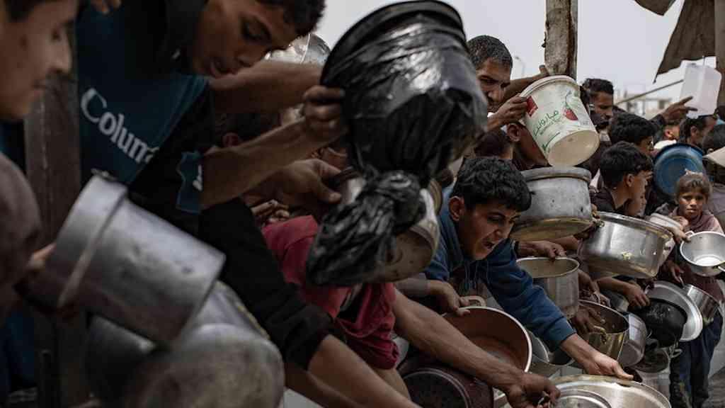 ONU alerta para esgotamento de alimentos em Gaza | Palestinos tentando receber porção de comida em uma cozinha improvisada em Jabalia