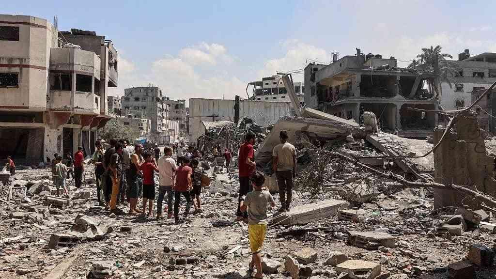 Israel anuncia possível ofensiva sem precedentes em Gaza | Rastro de destruição: palestinos caminham sobre escombros após bombardeios israelenses em Gaza 