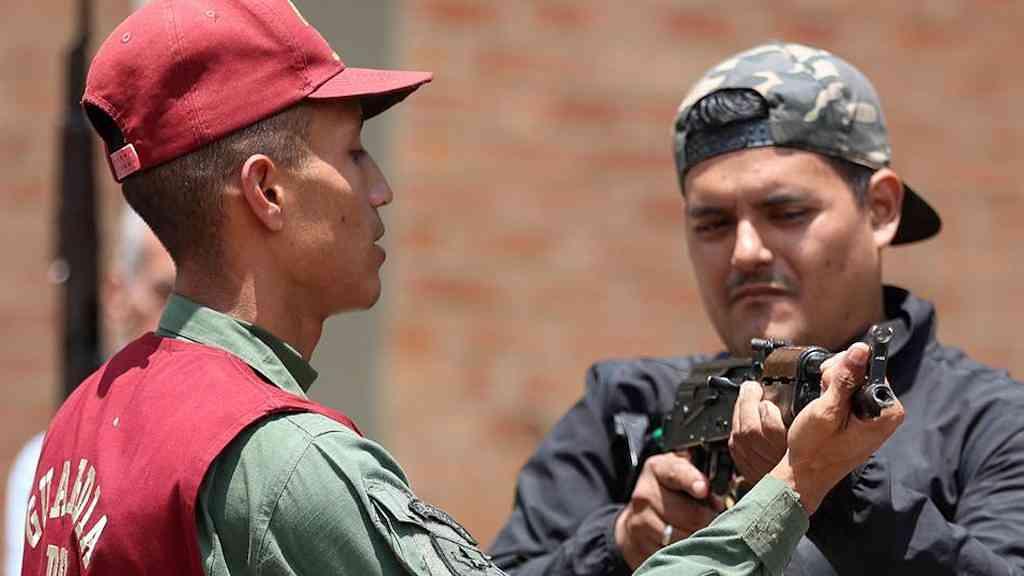 Milícias venezuelanas sob Maduro se preparam para enfrentar os EUA | Homem recebe treinamento com armas de um responsável por uma milícia civil