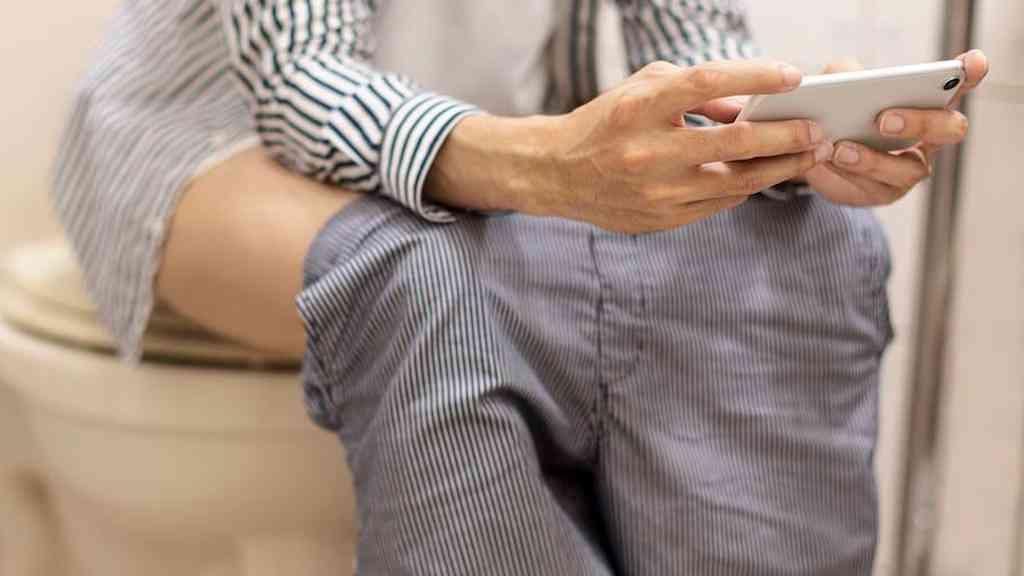 Estudo aponta que usar o celular no banheiro pode elevar risco de hemorroidas | Metade dos usuários de smartphone do estudo relatou ficar sentado no vaso sanitário por mais tempo do que o necessário