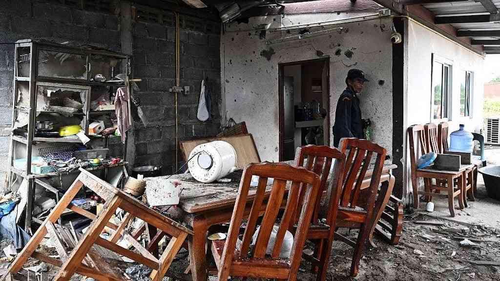 Confrontos voltam a explodir na divisa Camboja–Tailândia | Um guarda inspeciona uma casa evacuada que foi atingida pela artilharia cambojana no início da manhã, em uma vila próxima à fronteira entre a Tailândia e o Camboja, na província de Surin