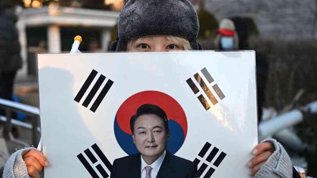 Ex-presidente enfrenta pedido de pena de morte em Seul | Apoiadora de Yoon mostra imagem de ex-presidente sobre a bandeira sul-coreana