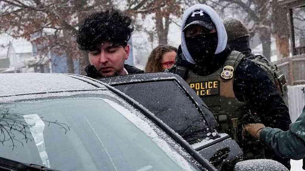 EUA suspendem ação migratória após mortes em Minneapolis | Um homem é conduzido para um carro após ser detido por agentes do Serviço de Imigração (ICE) durante uma operação de imigração em Minneapolis, Minnesota, EUA