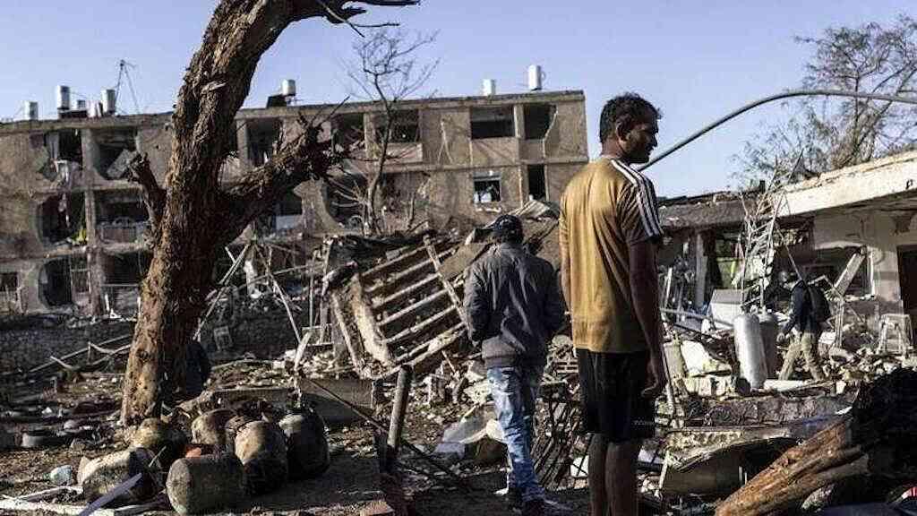 Teerã ameaça alvos estratégicos após ultimato de Trump | Pessoas observam local de ataque de míssil iraniano em Dinoma, Israel