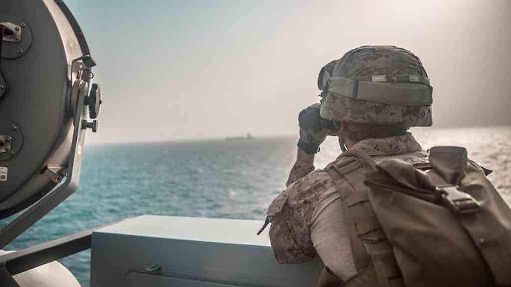 Irã libera passagem de navios com bens humanitários pelo estreito de Ormuz | Militar norte-americano no Estreito de Ormuz, observa atividade na costa do Irã