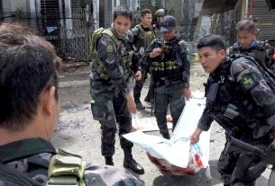 Homens do exército filipino transportam um dos corpos de vítimas do atentado