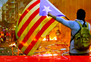 Manifestante desfralda a bandeira da Catalunha, em mais uma jornada de protestos na capital Barcelona