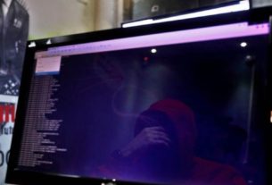 Reflexo de homem em monitor durante treinamento de cibersegurança em Israe