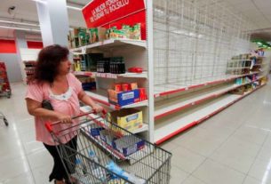 Mulher passa por prateleiras vazias em supermercado de Buenos Aires