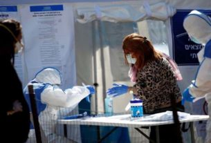 Agentes de saúde com roupa de proteção em local de votação montado para pessoas de quarentena devido ao coronavírus em Israel