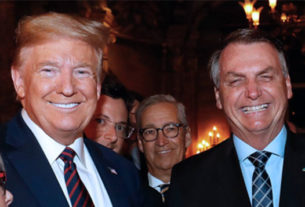 Wajngarten, contaminado com o novo coronavírus, escondido atrás do presidente Donald Trump, na foto com o mandatário brasileiro, Jair Bolsonaro