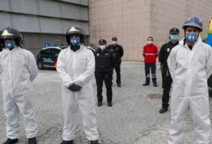 Bombeiros e policiais com trajes de proteção fazem um minuto de silêncio em Segovia, na Espanha