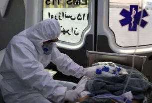 Integrante de equipe médica aguarda transferência de paciente em ambulância no Irã
