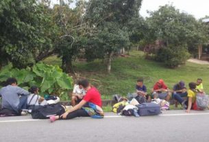 Grupo de venezuelanos na Colômbia descansa na beira da estrada, durante caminho de volta à Venezuela