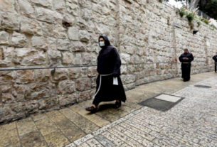 Um padre cumpre o caminho de Jesus, a caminho do calvário, com as ruas vazias