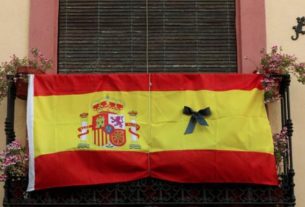 Bandeira da Espanha com marca de luto em varanda de apartamento em Ronda, na Espanha