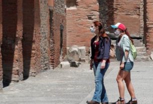 Turistas italianas usam máscaras de proteção ao visitar as ruínas de Pompeia, cidade histórica que foi reaberta para o público sob medidas de distanciamento social