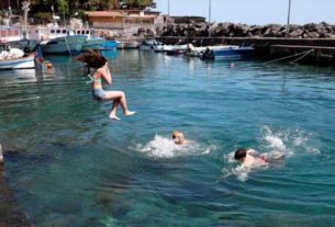 Crianças brincam na água em Catânia, na Itália