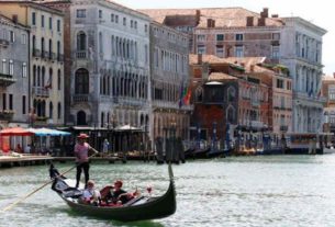 Turistas passeiam em gôndola em Veneza