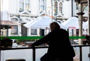 Homem aguarda pedido em café da Nova Zelândia após restrições domésticas serem suspensas