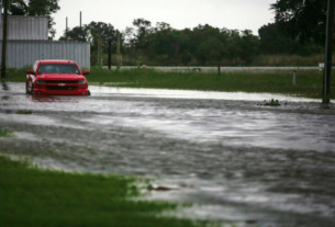 Carro parcialmente submerso após chuvas trazidas pelo furacão Laura em Louisiana, EUA